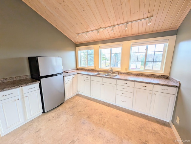 kitchen with rail lighting, stainless steel refrigerator, sink, and wooden ceiling