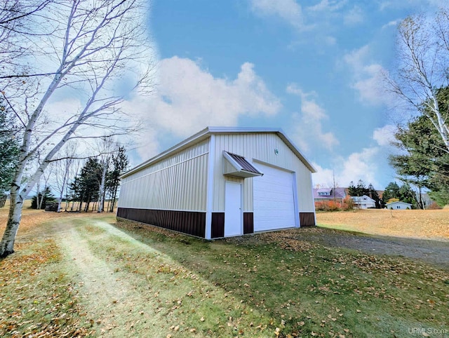 view of outdoor structure with a garage and a lawn