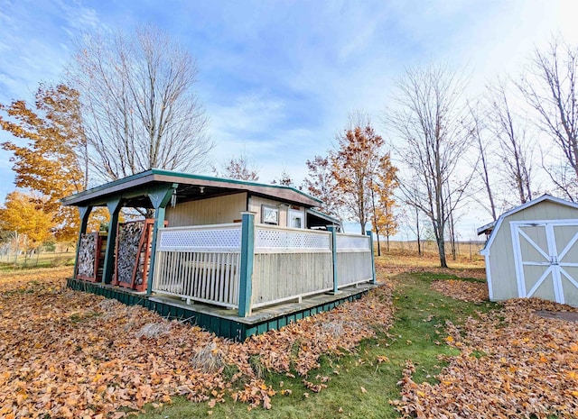 view of side of home with a wooden deck and a shed