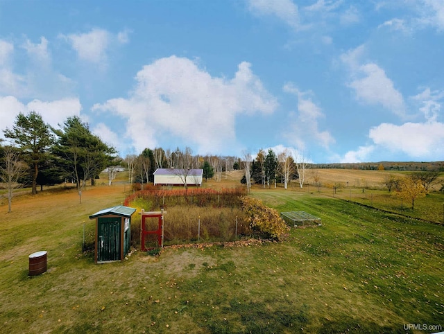 view of yard with an outdoor structure and a rural view