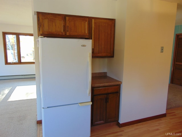 kitchen with light hardwood / wood-style flooring, white fridge, and baseboard heating