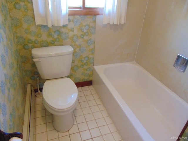 bathroom featuring a tub to relax in, tile patterned floors, and toilet