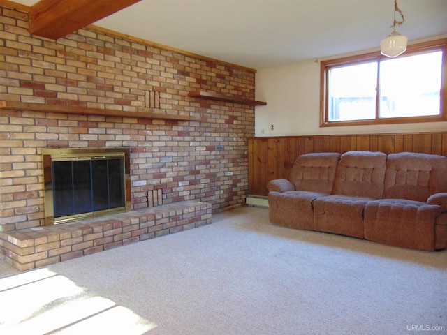 carpeted living room with a baseboard radiator, beamed ceiling, a fireplace, wooden walls, and brick wall