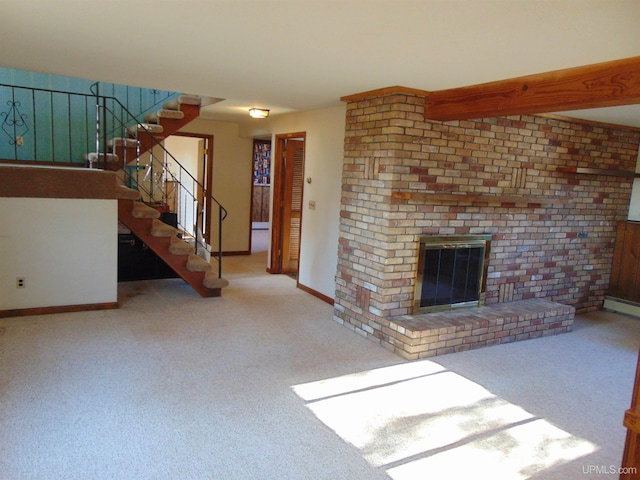 unfurnished living room featuring light carpet, a baseboard heating unit, brick wall, and a brick fireplace