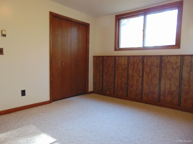 unfurnished bedroom with light carpet and a closet