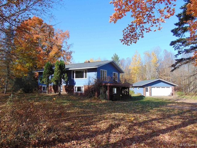 view of front facade featuring an outdoor structure, a garage, and a front lawn