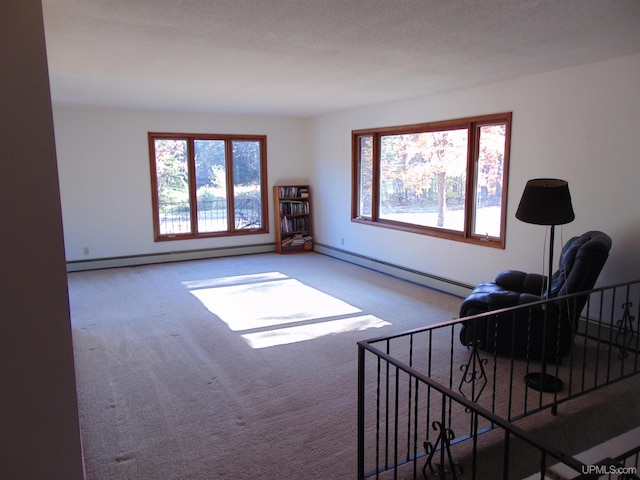 carpeted living room featuring a baseboard heating unit and a textured ceiling