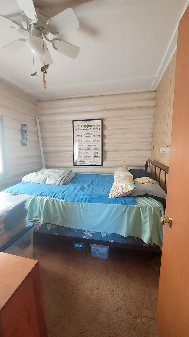 carpeted bedroom featuring wooden walls and ceiling fan