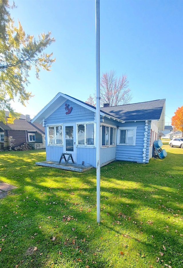 rear view of property featuring a yard