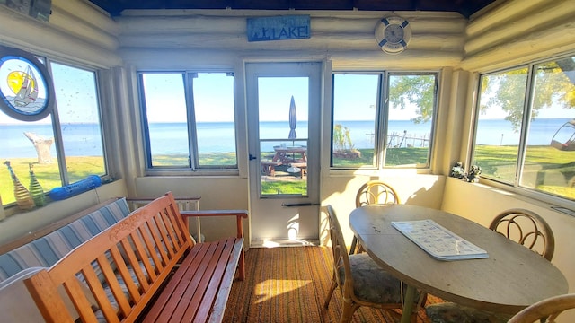 sunroom featuring a wealth of natural light and a water view