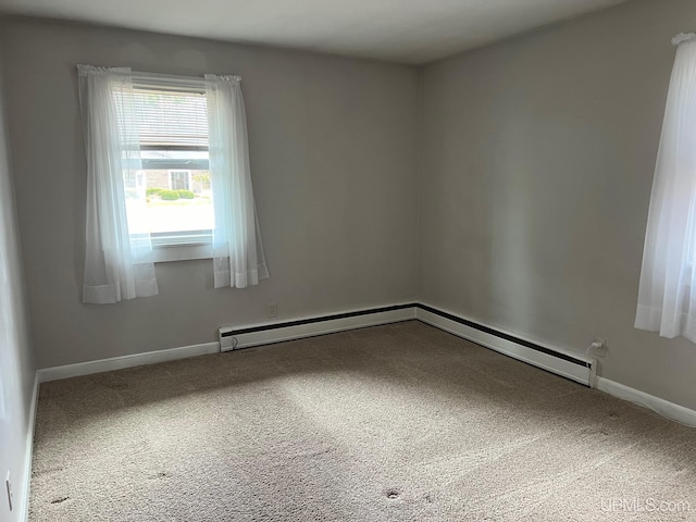 unfurnished room featuring carpet and a baseboard heating unit