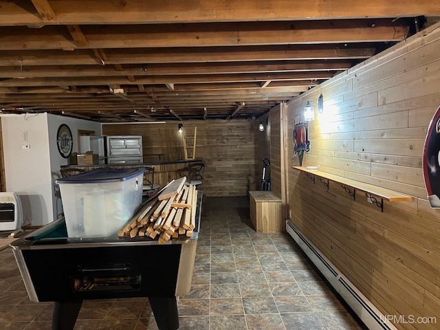 interior space featuring a baseboard heating unit, wooden walls, and heating unit