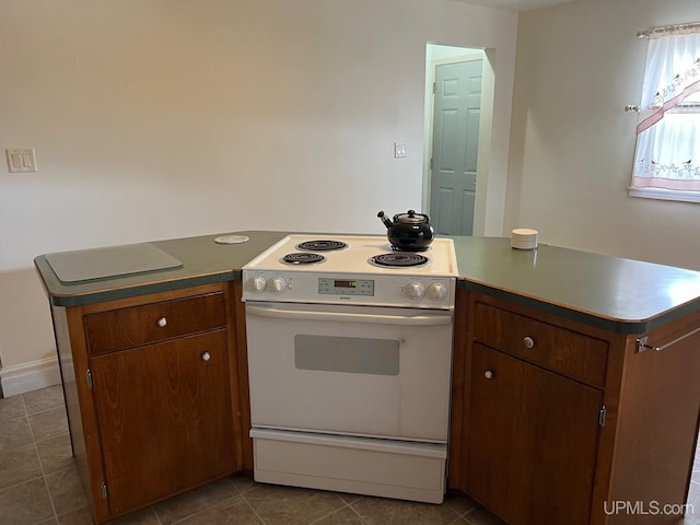 kitchen featuring electric range and dark tile patterned flooring