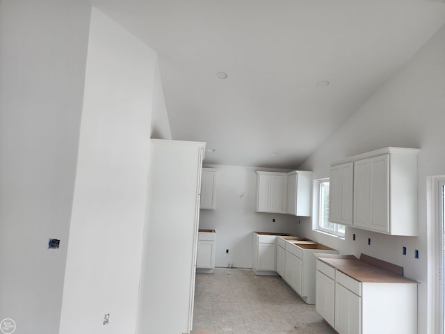 kitchen featuring white cabinetry and lofted ceiling