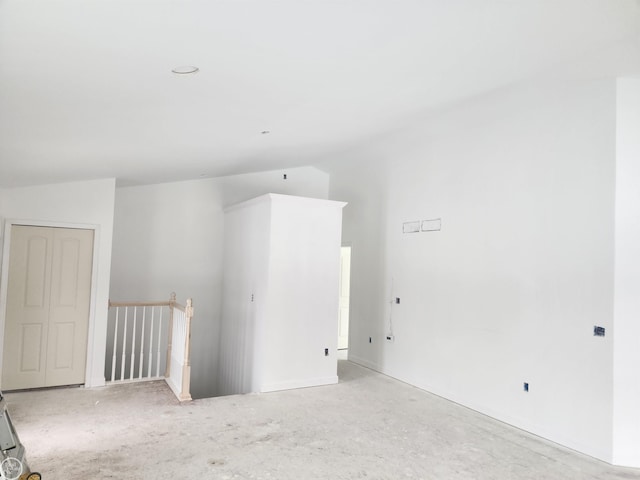 unfurnished room with vaulted ceiling