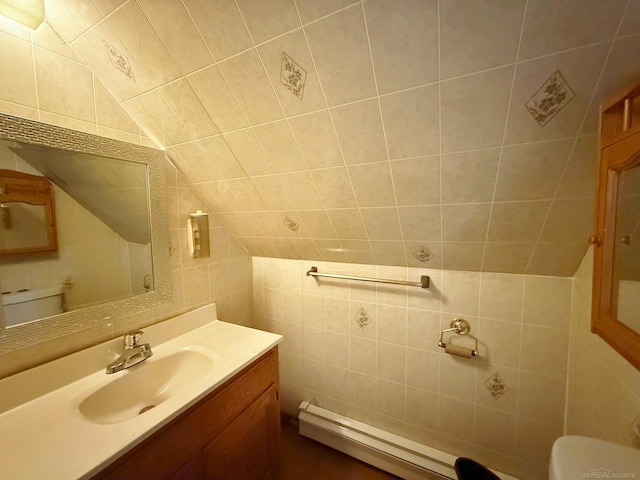 bathroom with toilet, vanity, tile walls, and vaulted ceiling