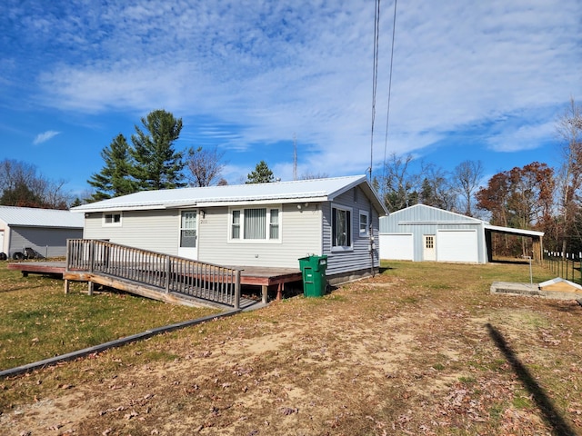 view of front of home featuring an outdoor structure, a front yard, a wooden deck, and a garage