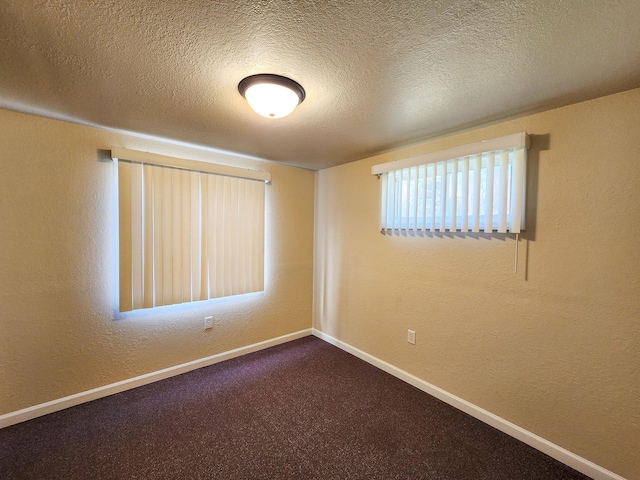 empty room featuring a textured ceiling and carpet