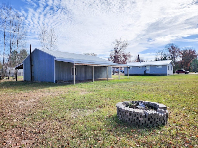 view of yard with a fire pit and a carport