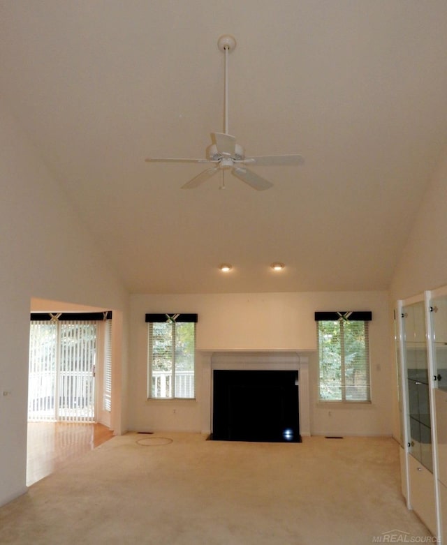 unfurnished living room featuring carpet flooring, high vaulted ceiling, and ceiling fan