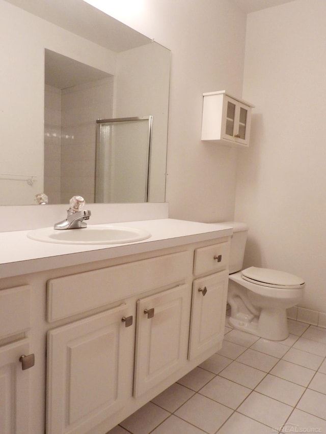 bathroom with vanity, tile patterned floors, toilet, and an enclosed shower