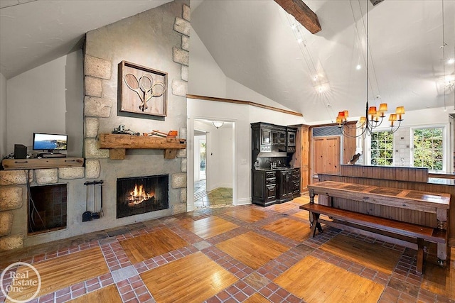 interior space featuring high vaulted ceiling, a notable chandelier, and a stone fireplace