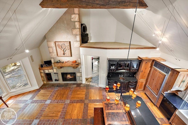 living room with a stone fireplace and high vaulted ceiling