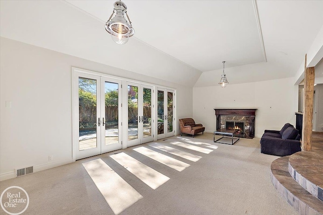 living room with light carpet, french doors, and a high end fireplace