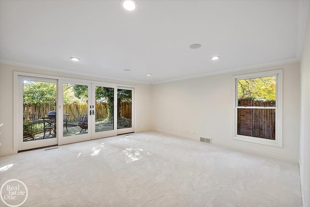 carpeted empty room featuring ornamental molding and french doors