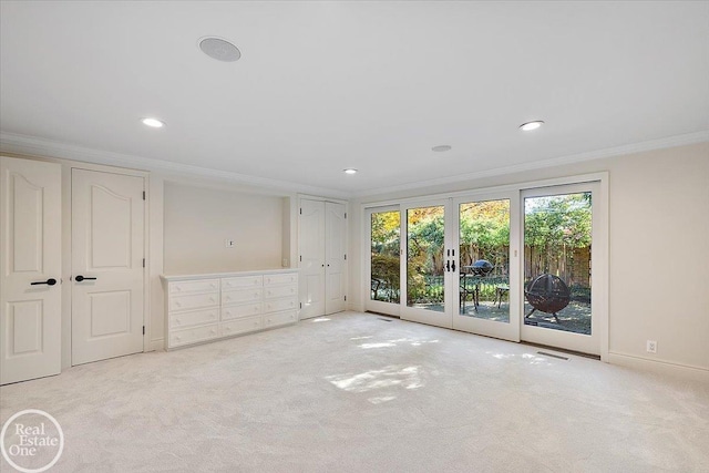 carpeted empty room with crown molding and french doors