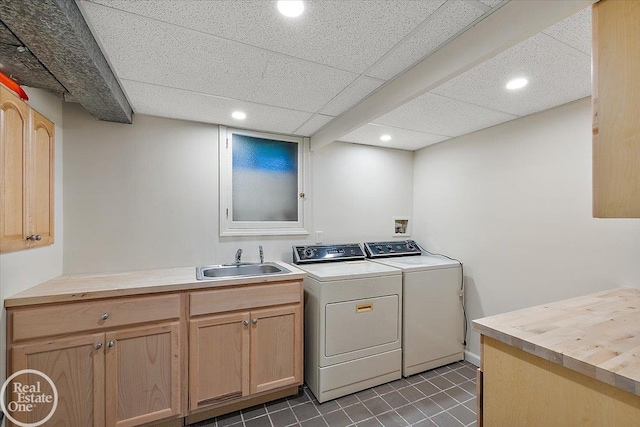 laundry area with cabinets, independent washer and dryer, and sink