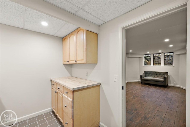 kitchen with a drop ceiling and light brown cabinetry