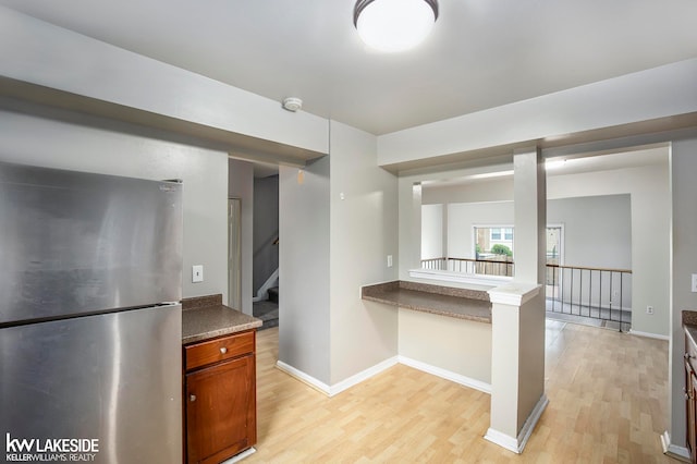 kitchen with light hardwood / wood-style flooring and stainless steel fridge