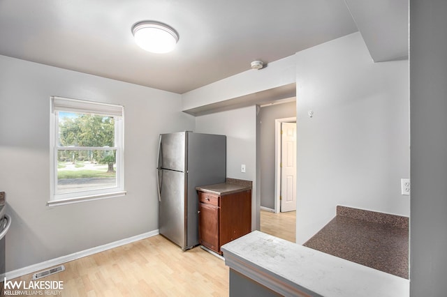 kitchen with light hardwood / wood-style floors and stainless steel fridge