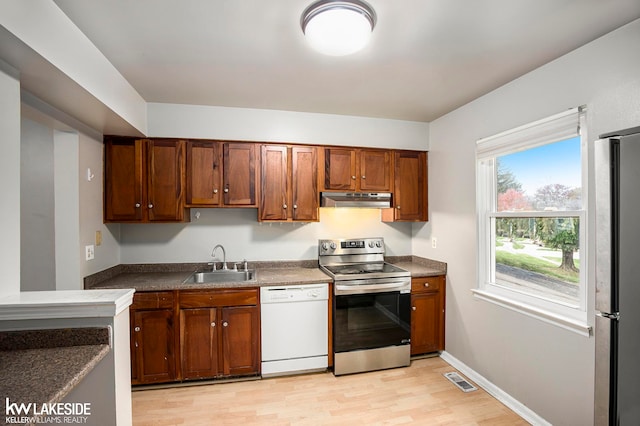 kitchen featuring appliances with stainless steel finishes, sink, and light wood-type flooring