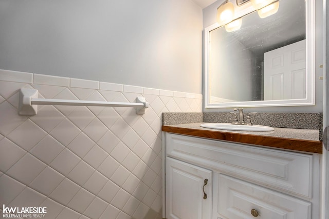 bathroom with vanity and tile walls