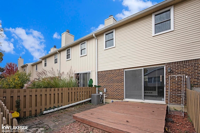 rear view of property with cooling unit and a deck