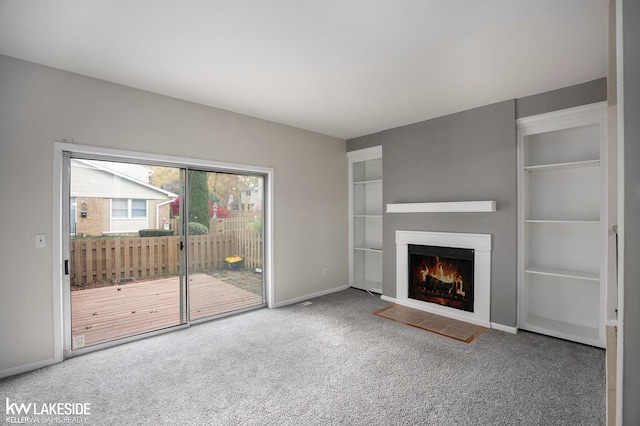 unfurnished living room featuring built in features and carpet floors