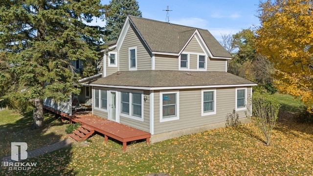 view of side of property featuring a wooden deck and a lawn