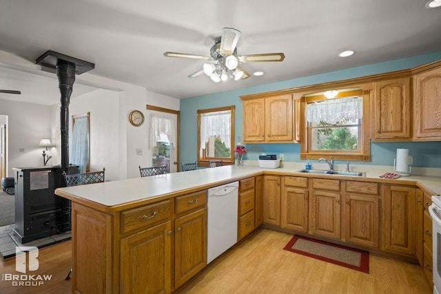 kitchen with white appliances, a wealth of natural light, sink, and kitchen peninsula