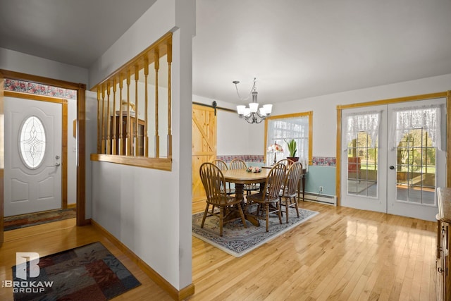 foyer entrance with an inviting chandelier, a baseboard heating unit, a barn door, and hardwood / wood-style floors