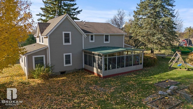 rear view of property with a lawn and a sunroom