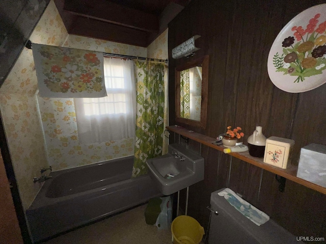 bathroom with shower / tub combo, toilet, and wood walls