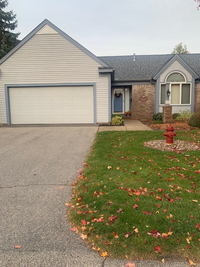 single story home featuring a front lawn and a garage