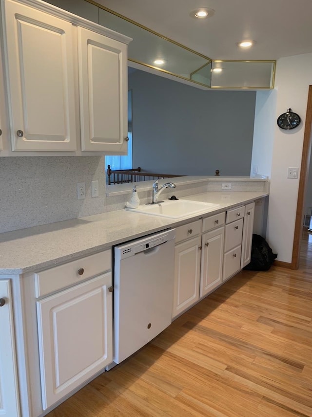 kitchen with white cabinets, light hardwood / wood-style floors, and white dishwasher