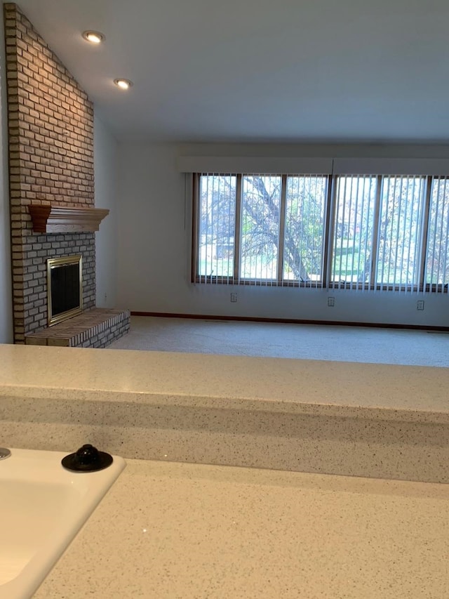 unfurnished living room featuring a fireplace and vaulted ceiling