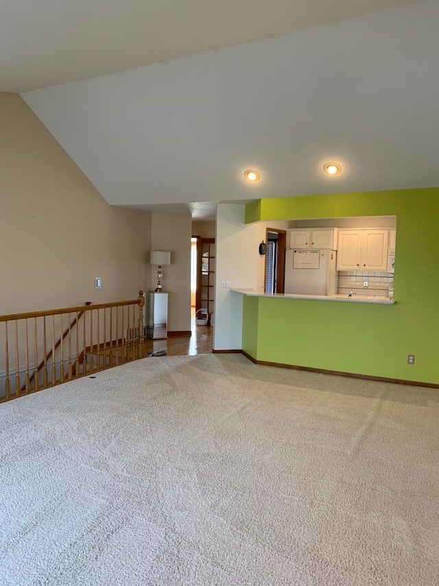 interior space with vaulted ceiling and carpet floors