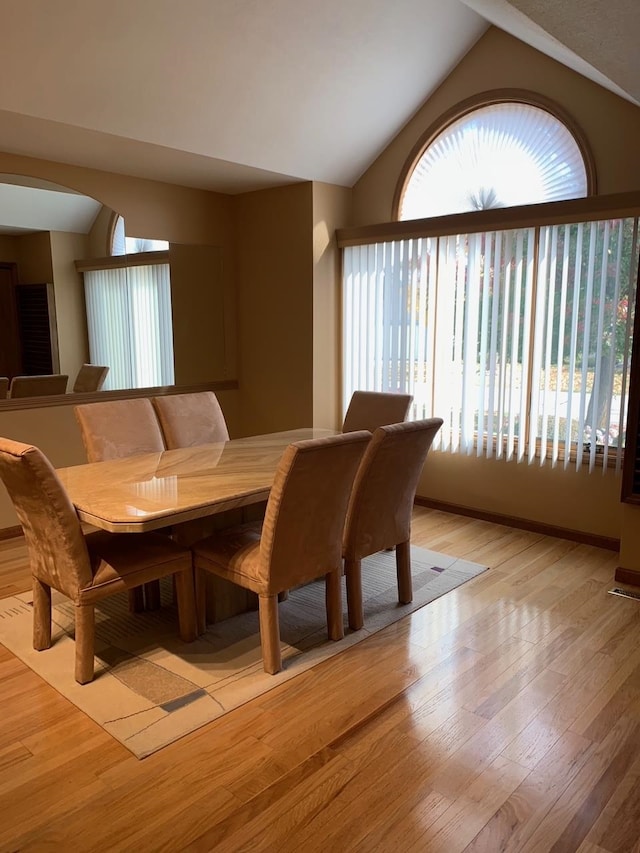 dining space with light hardwood / wood-style floors and lofted ceiling