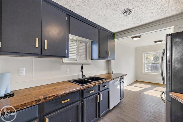 kitchen featuring fridge, white dishwasher, sink, crown molding, and light hardwood / wood-style floors