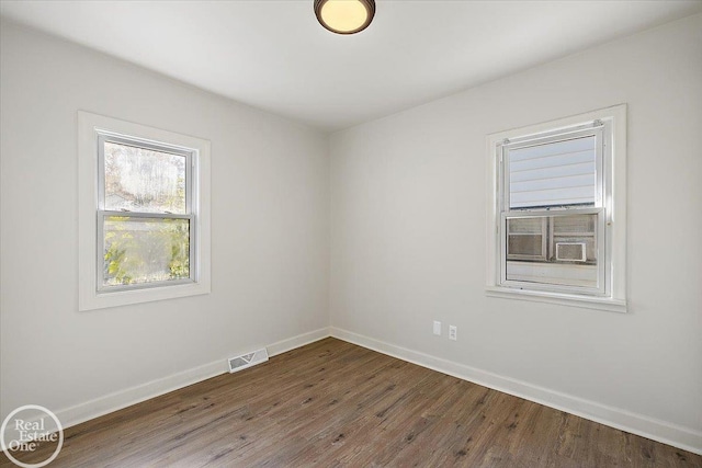 unfurnished room with dark wood-type flooring